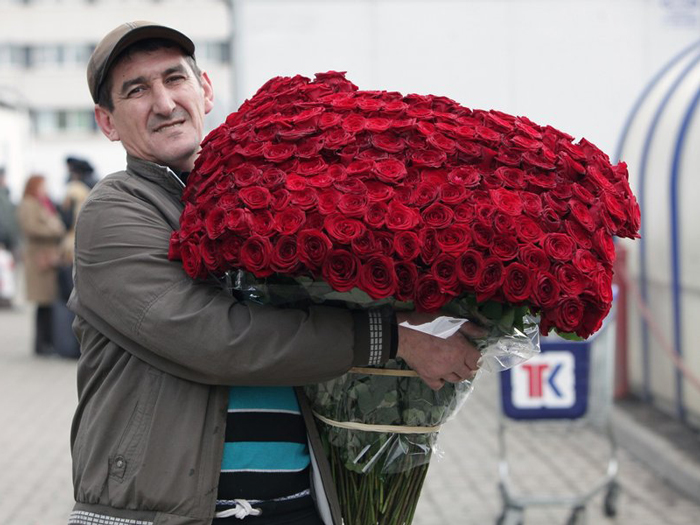 огромный букет цветов в руках мужчины